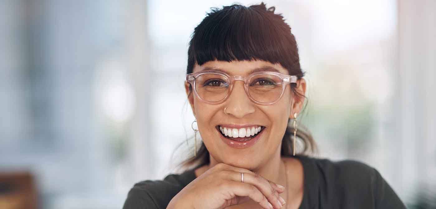 a woman smiling with her hand resting on her chin