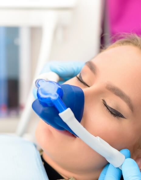 Woman in dental chair with nitrous oxide sedation mask on her face