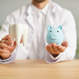 a dentist holding a piggy bank